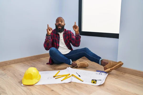 African American Man Sitting Floor New Home Looking Blueprints Amazed — Stock Photo, Image