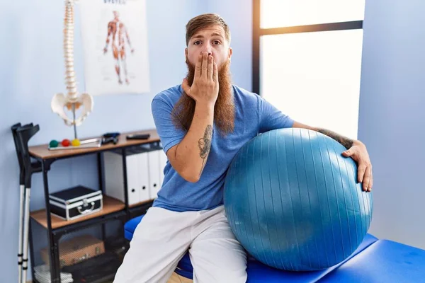 Redhead Man Long Beard Holding Pilates Ball Rehabilitation Clinic Covering — стоковое фото