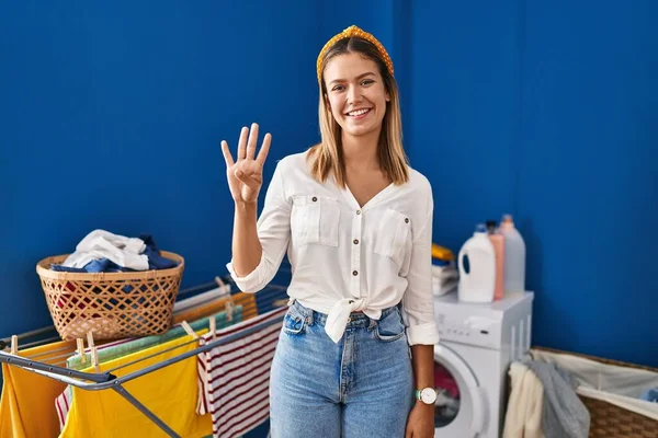 Young Blonde Woman Laundry Room Showing Pointing Fingers Number Four — Foto Stock