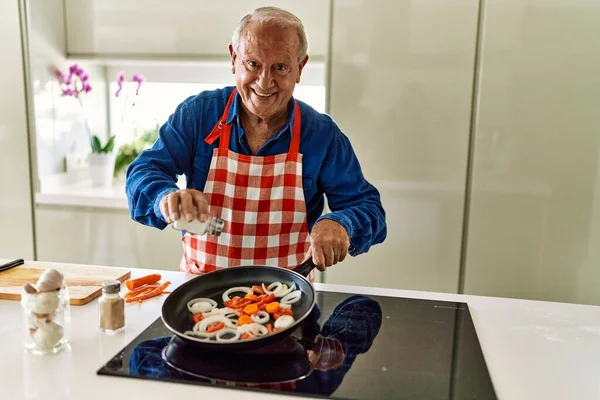 Ηλικιωμένος Άνθρωπος Χαμογελά Αυτοπεποίθηση Ρίχνει Αλάτι Στο Τηγάνι Στην Κουζίνα — Φωτογραφία Αρχείου