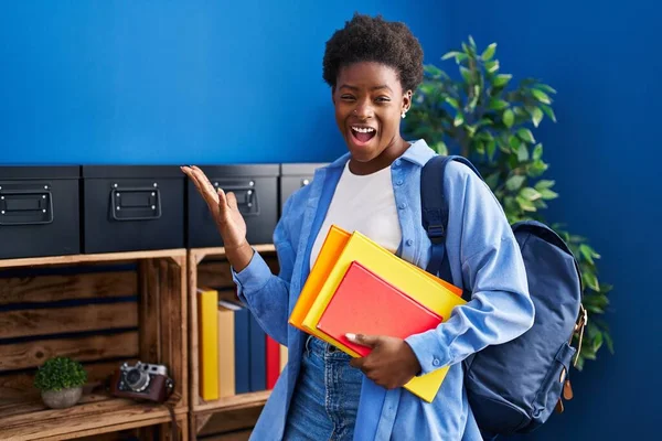 African American Woman Wearing Student Backpack Holding Books Celebrating Victory — ストック写真
