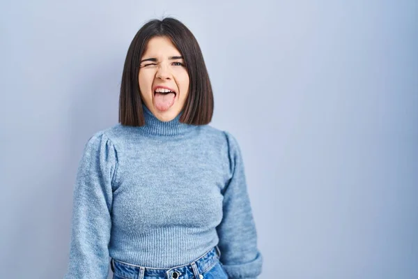Mavi Arka Planda Dikilen Genç Spanyol Kadın Komik Bir Ifadeyle — Stok fotoğraf