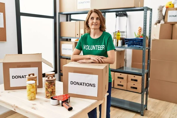 Middle Age Hispanic Woman Wearing Volunteer Uniform Leaning Donations Box — Fotografia de Stock