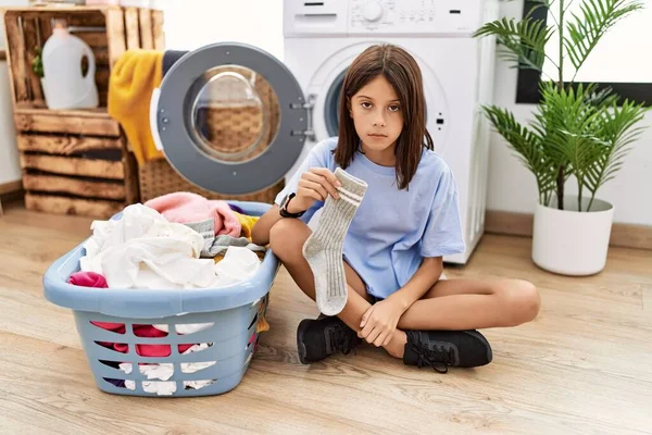 Young Hispanic Girl Doing Laundry Holding Socks Looking Sleepy Tired — Stockfoto