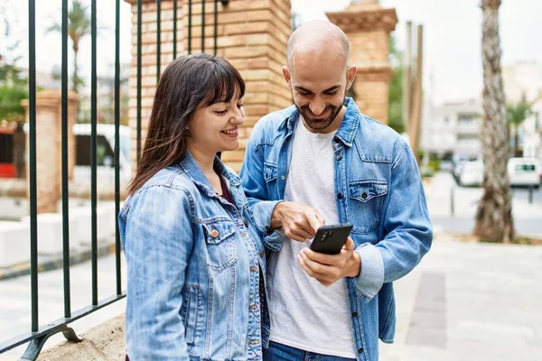 Νεαρό Ζευγάρι Ισπανόφωνων Χαμογελά Χαρούμενος Χρησιμοποιώντας Smartphone Στην Πόλη — Φωτογραφία Αρχείου