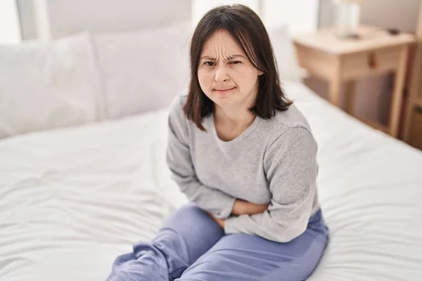 Ung Kvinna Med Ner Syndrom Lider För Menstruationssmärta Sitter Sängen — Stockfoto