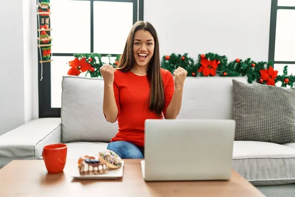 Jovem Morena Usando Laptop Sentado Sofá Natal Comemorando Surpreso Surpreso — Fotografia de Stock