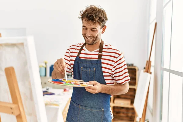 Νεαρός Ισπανός Άντρας Χαμογελάει Αυτοπεποίθηση Ζωγραφίζοντας Στο Στούντιο Τέχνης — Φωτογραφία Αρχείου