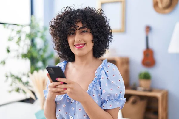 Молода Жінка Близького Сходу Посміхається Впевнено Використовуючи Смартфон Вдома — стокове фото