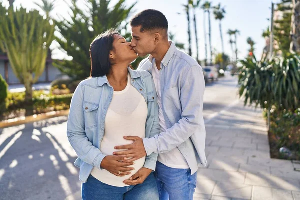 Young Latin Couple Expecting Baby Touching Belly Kissing Park — Stockfoto