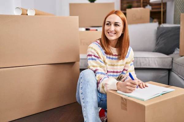 Jonge Kaukasische Vrouw Glimlachen Zelfverzekerd Schrijven Notebook Nieuw Huis — Stockfoto