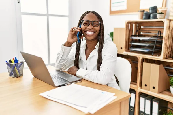 Black Woman Braids Working Office Speaking Phone Winking Looking Camera — Φωτογραφία Αρχείου