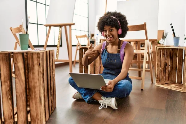在艺术工作室里 年轻的非洲裔美国女人用笔记本电脑指着一个快乐而自豪的自我微笑 — 图库照片