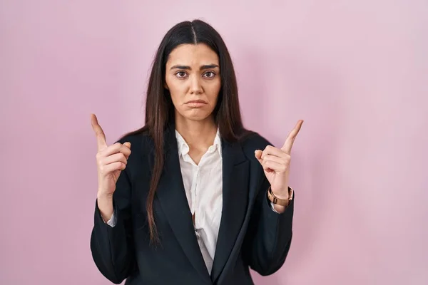 Mujer Morena Joven Con Estilo Negocios Sobre Fondo Rosa Apuntando — Foto de Stock