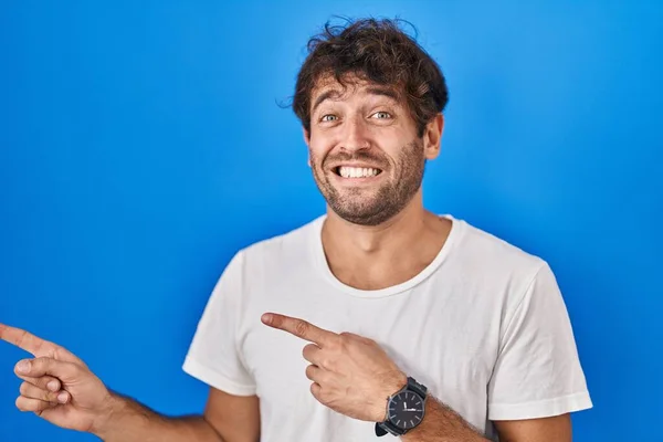 Hispánec Mladý Muž Stojící Nad Modrým Pozadím Ukazuje Stranou Ustaraný — Stock fotografie