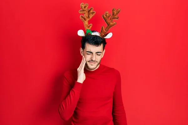 Mladý Hispánec Nosí Roztomilé Vánoční Sobí Rohy Dotýkají Úst Bolestivým — Stock fotografie