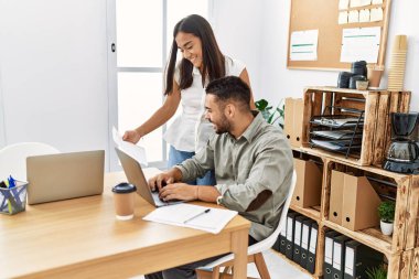 Ofiste çalışırken gülümseyen iki Latin iş adamı..