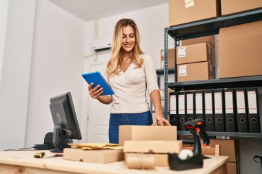 Ofiste çalışan genç sarışın iş kadını touchpad kullanıyor.