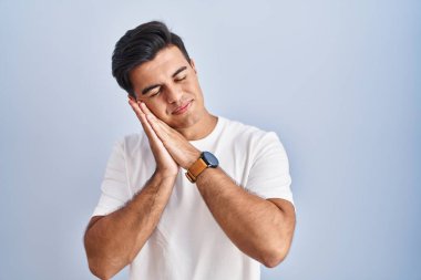 Mavi arka planda dikilen İspanyol adam uyuyordu. Yorgun düşler görüyordu ve elleriyle poz veriyordu. Gözleri kapalı gülümsüyordu.. 