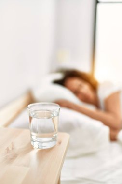 Orta yaşlı İspanyol kadın yatak odasında yatakta uyuyor.