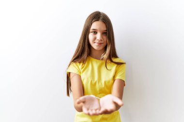 Young brunette teenager standing together over isolated background smiling with hands palms together receiving or giving gesture. hold and protection 