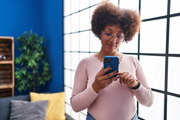 Африканська Американка Впевнено Посміхається Користуючись Вдома Смартфоном — стокове фото