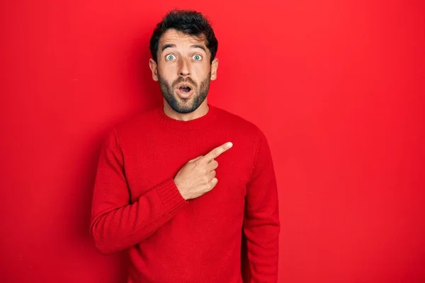 Homem Bonito Com Barba Vestindo Camisola Vermelha Casual Surpreso Apontando — Fotografia de Stock