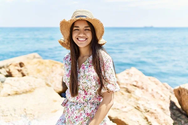 Young Latin Girl Wearing Summer Hat Sitting Rock Beach — стоковое фото