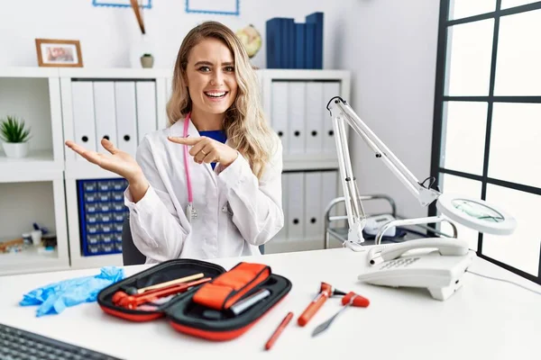 Young Beautiful Doctor Woman Reflex Hammer Medical Instruments Amazed Smiling — Stock fotografie