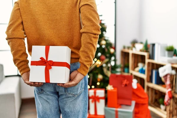 Man Holding Gift His Back Standing Christmas Tree Home — Stockfoto