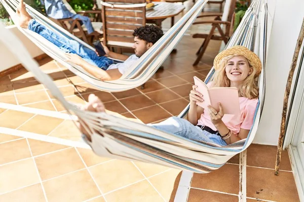 Jeune Couple Souriant Heureux Détendu Utilisant Smartphone Livre Lecture Allongé — Photo