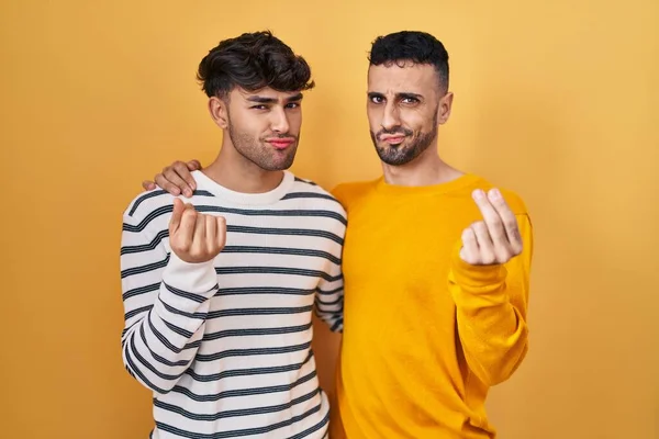 Unga Latinamerikanska Homosexuella Par Står Över Gul Bakgrund Gör Pengar — Stockfoto