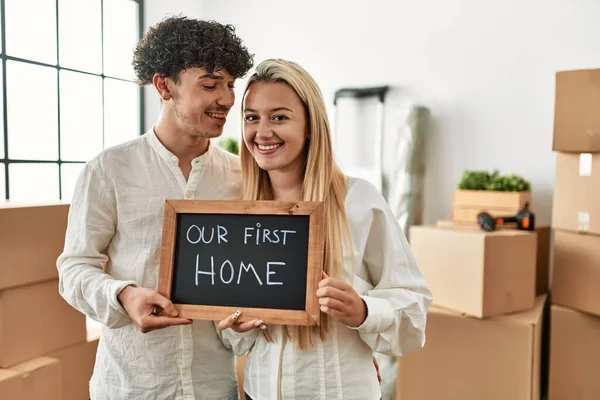 Young Beautiful Couple Smiling Happy Holding Blackboard Our First Home — Stock Photo, Image