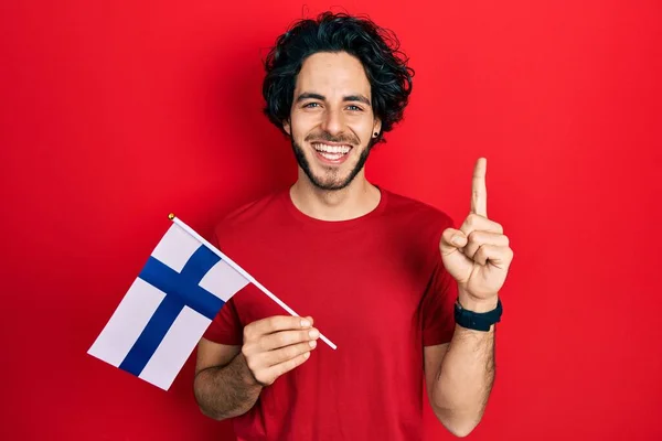 Een Knappe Spaanse Man Met Een Finse Vlag Die Glimlacht — Stockfoto