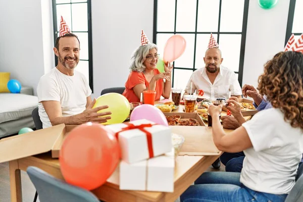 Group of middle age friends smiling happy celebrate birthday at home.