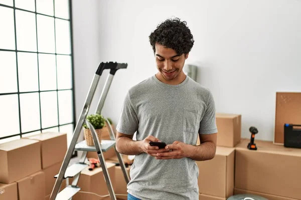 Jovem Hispânico Homem Sorrindo Feliz Usando Smartphone Nova Casa — Fotografia de Stock