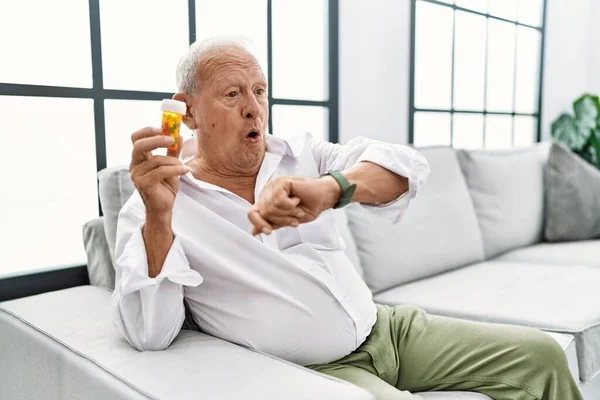 Senior Man Holding Pills Looking Watch Time Worried Afraid Getting — Foto Stock