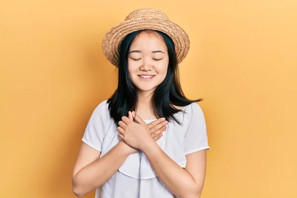 Young Chinese Girl Wearing Summer Hat Smiling Hands Chest Closed — Stockfoto