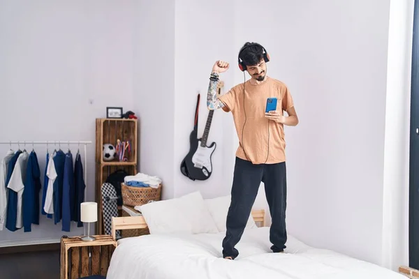 Young Hispanic Man Listening Music Dancing Bed Bedroom — Fotografia de Stock