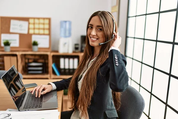 Young hispanic woman call center agent having video call working at office
