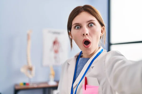 Young Physiotherapist Woman Working Pain Recovery Clinic Scared Amazed Open — Fotografia de Stock