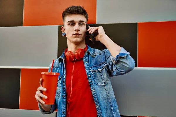 Young Caucasian Guy Drinking Soda Speaking Phone Leaning Wall — Fotografia de Stock