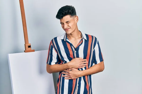 Young Hispanic Man Standing Close Empty Canvas Hand Stomach Because — 스톡 사진