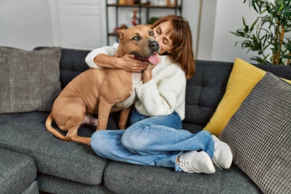 Young Caucasian Woman Kissing Hugging Dog Sitting Sofa Home — Stockfoto