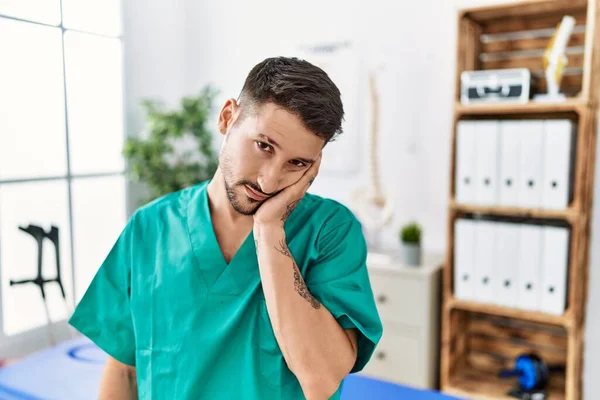 Young Physiotherapist Man Working Pain Recovery Clinic Thinking Looking Tired — Foto de Stock