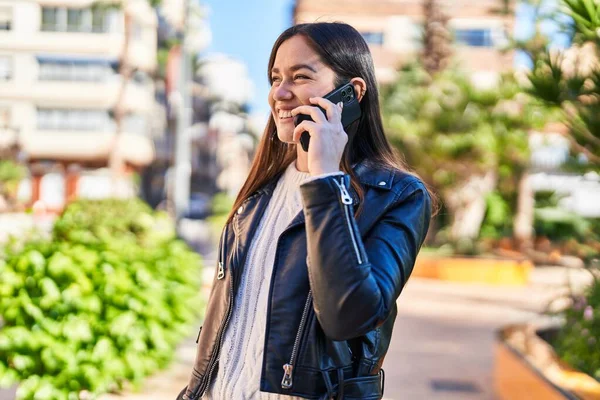 公園でスマホで自信を持って話してる若い女性 — ストック写真