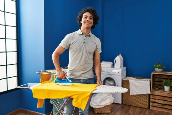 年轻的惊慌失措的男人在洗衣房自信地熨烫衣服 — 图库照片
