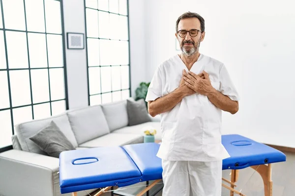 Middle Age Physiotherapy Man Working Home Smiling Hands Chest Closed — Stockfoto