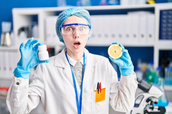 Beautiful Woman Working Scientist Laboratory Holding Pills Lemon Shock Face — 스톡 사진