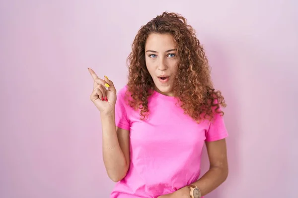 Junge Kaukasische Frau Steht Über Rosa Hintergrund Überrascht Zeigt Mit — Stockfoto